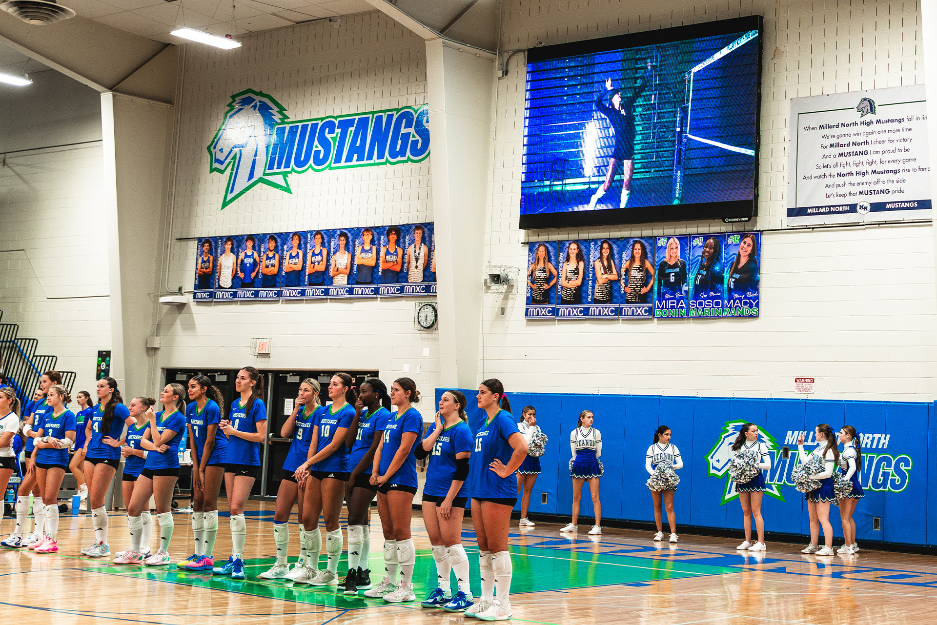 The Mustangs line up as live video plays on the ScoreVision display overhead.