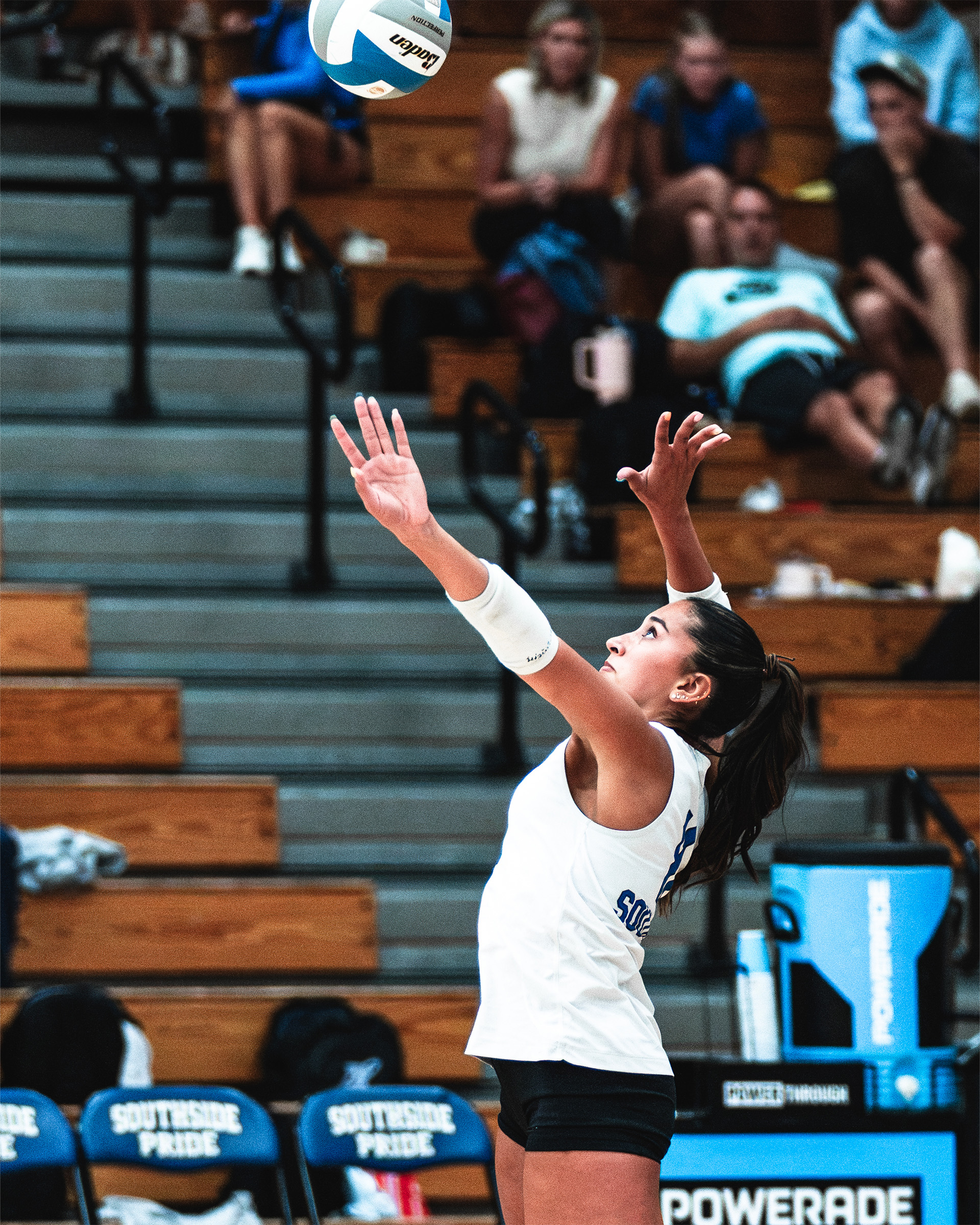 A Titans server stays focused as she sends the ball into play.