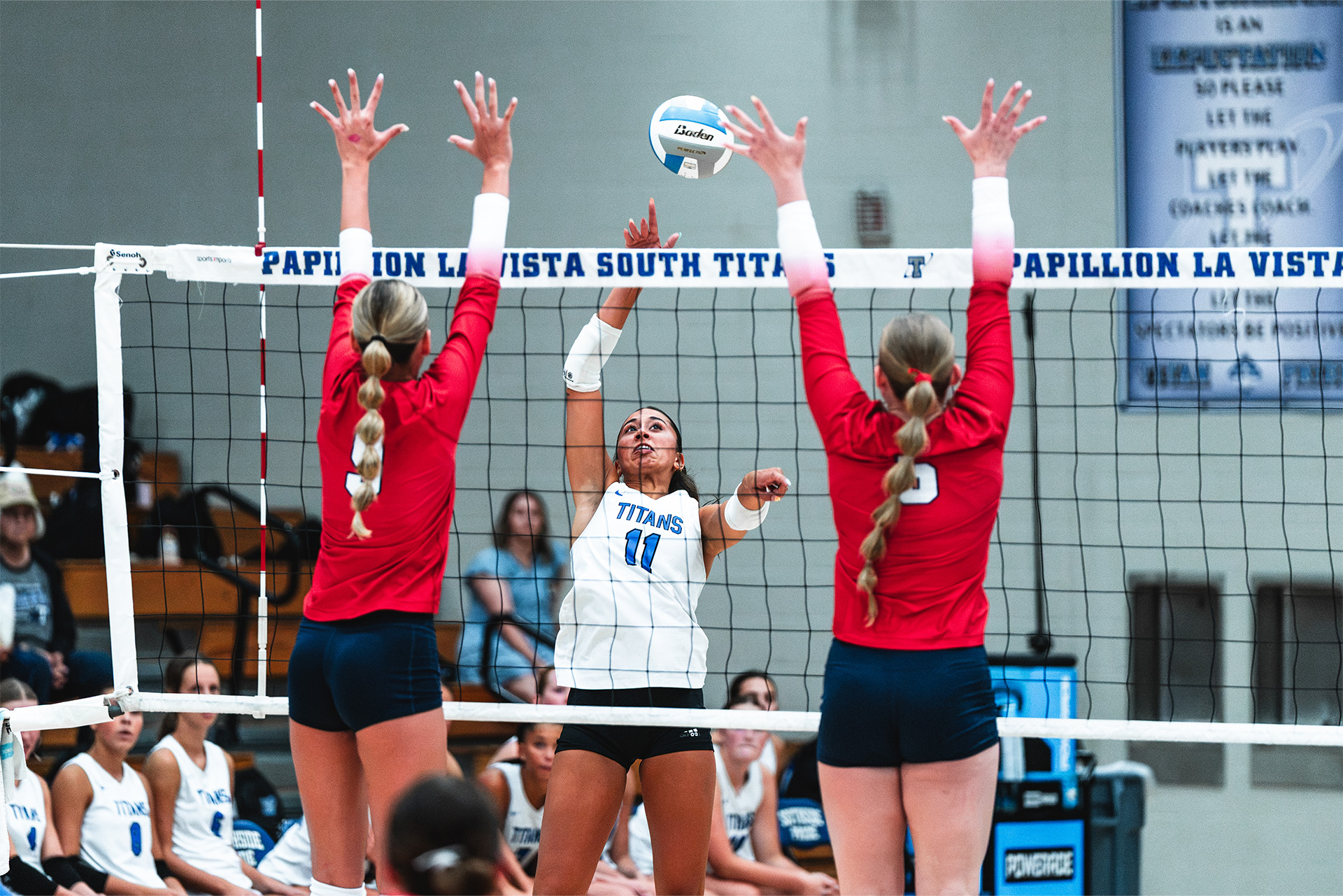 A Titans attacker challenges a two-player block at the net.