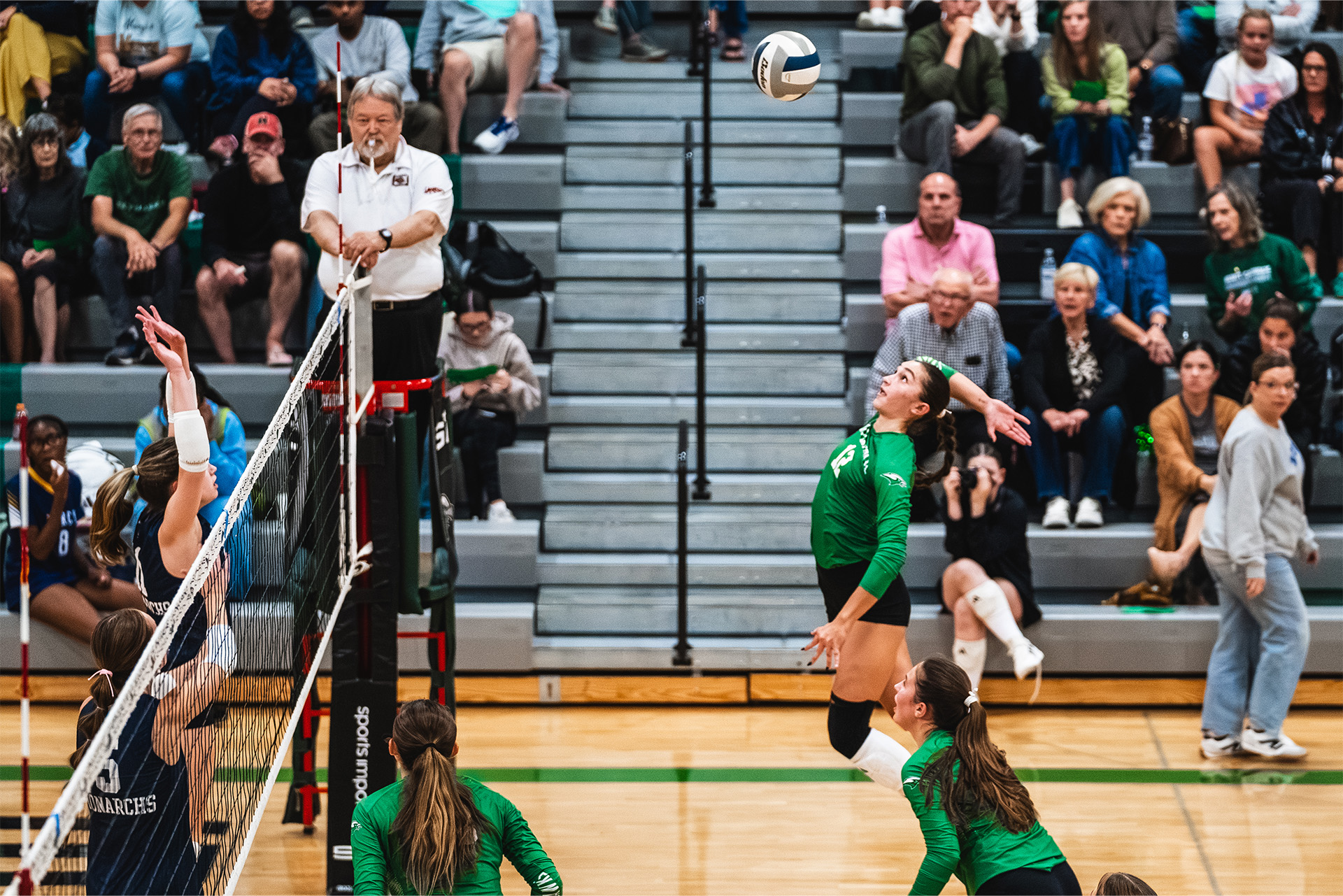 A Skutt Catholic hitter leaps to attack against the opposing block.