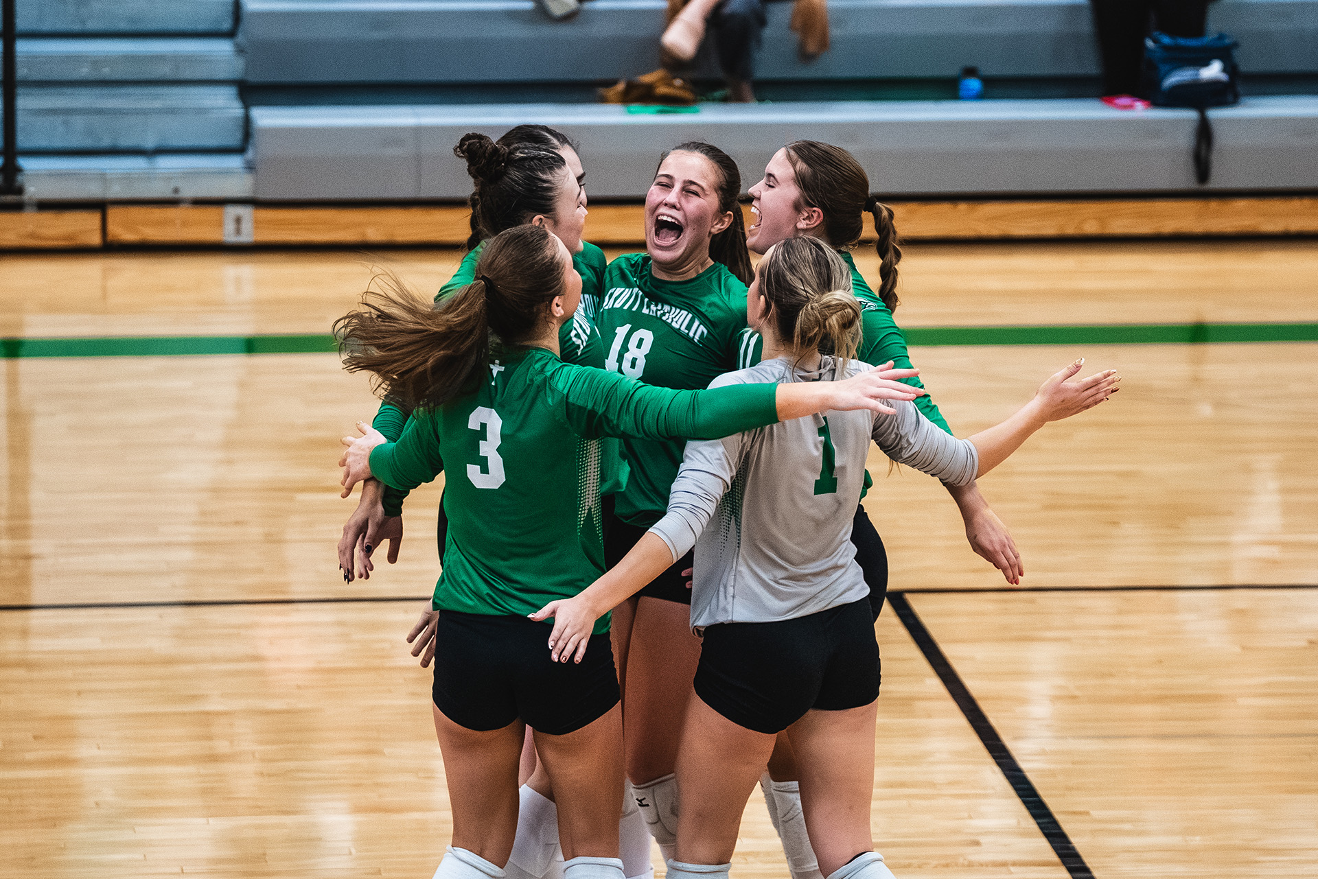 Skutt Catholic teammates celebrate together on the court.