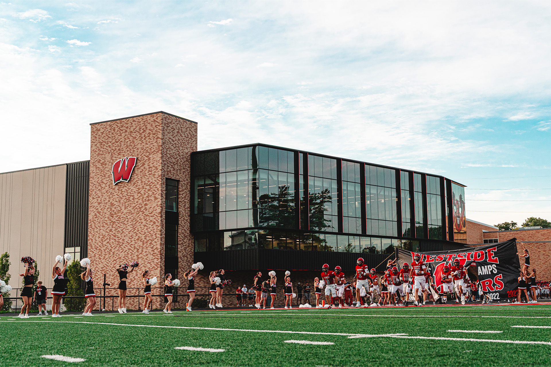 The Warriors charge onto Phelps Field as cheerleaders welcome the team.