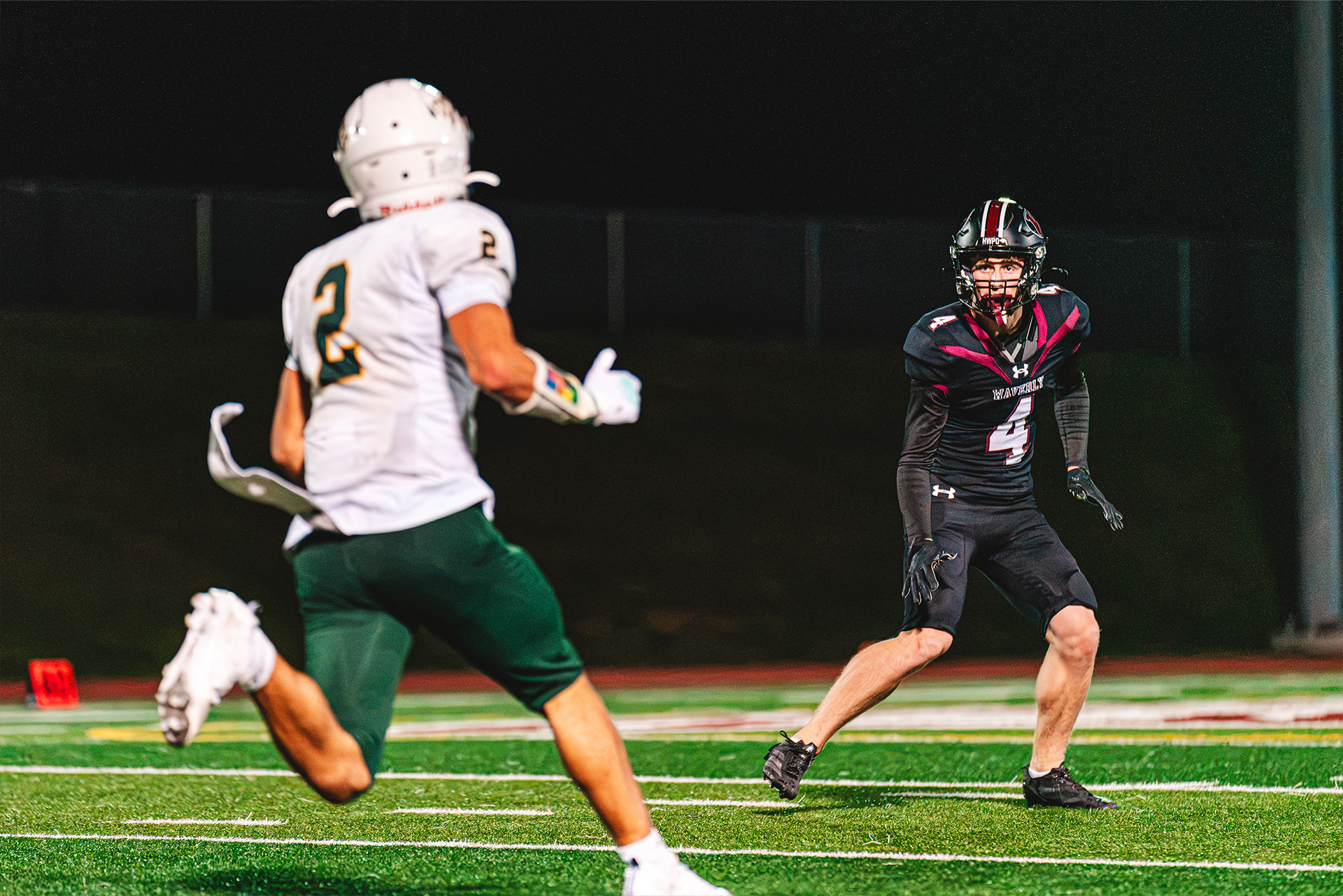 A Waverly defender tracks an opposing player under the stadium lights.