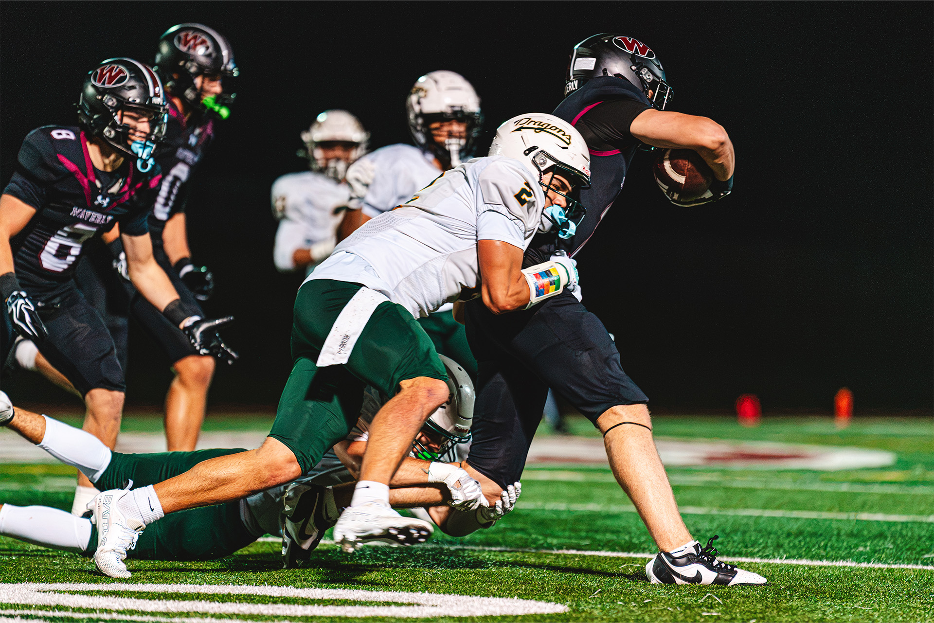 A Waverly runner fights for extra yards as opposing defenders close in.